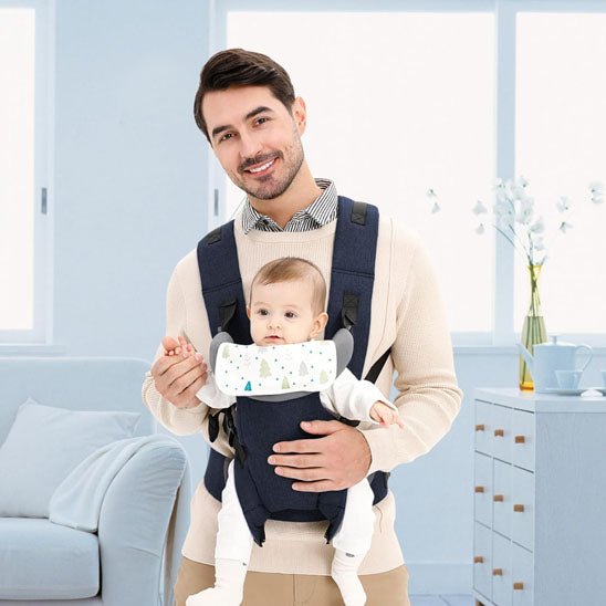 Porte bebe papa sourit et tient la main de bébé devant