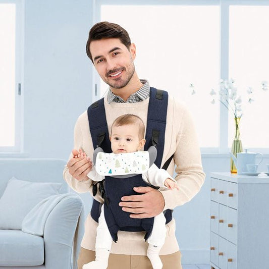 Porte bebe papa sourit et tient la main de bébé devant